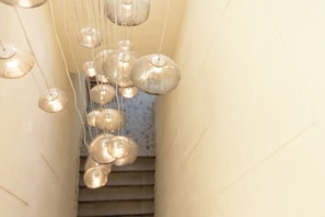A staircase with hanging spherical light fixtures.