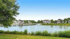 Un quartiere residenziale con case, un lago e un molo di legno.