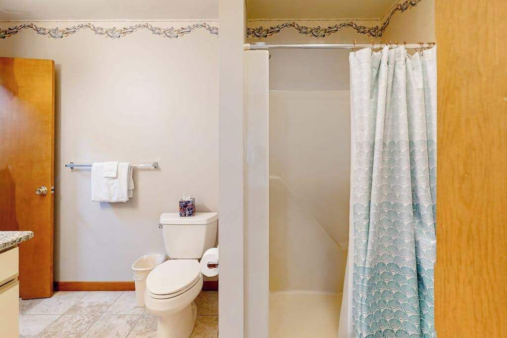 Ein Badezimmer mit Toilette, Duschvorhang und Handtuchhalter.