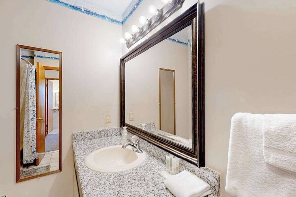 A bathroom with a sink, mirror, and towel. - Gull's Nest gated home with deck, grill, & private neighborhood beach access (Bethany Beach)