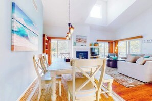 A spacious living area with a dining table, chairs, a sofa, and a television. - Sea Colony condo with multiple pools, sports courts & beach access (Bethany Beach)