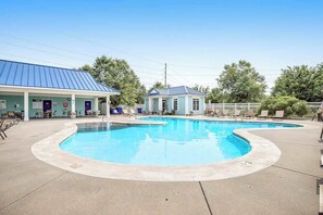 A swimming pool with lounge chairs, a covered area with a blue roof, and a small building with a blue roof. - Dog-friendly Millville by the Sea home with large yard, porch, grill, AC, & WiFi (Millville)