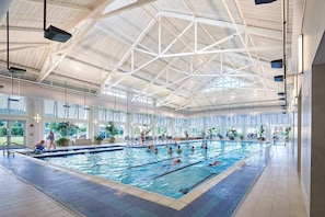 An indoor swimming pool with a high ceiling and large windows. - Bayside Resort home with paid-access pools & other resort amenities (Selbyville)