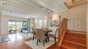 Un vaste espace de vie comprenant une table à manger, des chaises et un escalier.