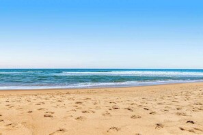 A beach with footprints in the sand and a clear blue sky. - Sea Colony beachfront 6th-floor condo with 12 pools, 2 hot tubs, private beach (Bethany Beach)