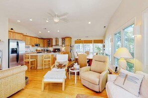 A spacious living area with a kitchen, dining area, and seating. - Town of South Bethany Beach home with sunroom and water views - dogs ok (Bethany Beach)