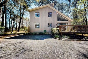 A modern wooden cabin with a sloped roof, surrounded by trees. - Secluded, 4-BR, dog-friendly home, private beach (Bethany Beach)