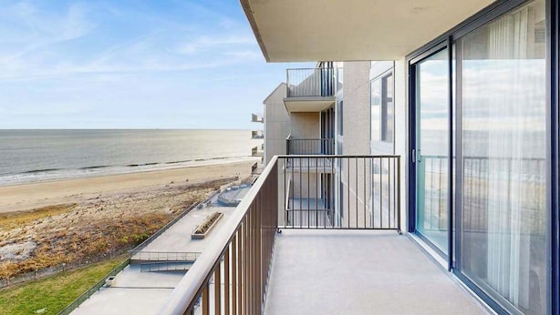 Un balcon avec vue sur la plage et l’océan.