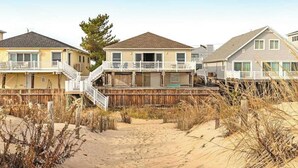 Una propiedad frente a la playa con varias casas, pasarelas de madera y una playa arenosa.