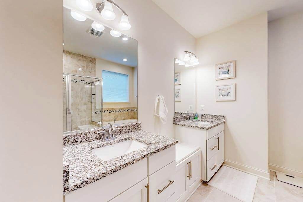 Un bagno con uno specchio grande, due lavabi e una doccia.