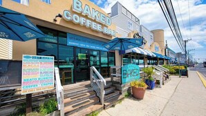 En byggnad med en skylt där det står ”BAKED COFFEE BAR” och en menytavla som visar vilka frukostalternativ som finns.