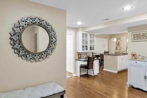 Una habitación con un espejo grande y decorativo, una cama, un escritorio y una zona de kitchenette.