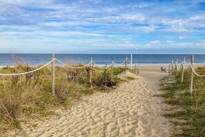 A sandy beach path leading to the ocean, with a rope barrier and wooden posts. - Town of Dewey Beach retreat with balcony & patio near the water - dog-friendly (Dewey Beach)