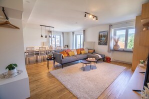 Uma sala de estar moderna com sofá, mesa de centro e área de jantar.