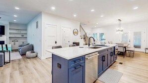 Een moderne keuken met een centraal eiland, inbouwapparatuur en een eetgedeelte met uitzicht.