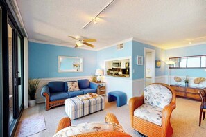 A living room with a blue wall, a ceiling fan, a sofa, a chair, and a small table. - Sea Colony 7th floor condo w/ free WiFi, shared tennis court - ocean view (Bethany Beach)