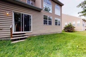 A two-story house with a front porch, large windows, and a well-maintained lawn. - Wedgefield house w/ free WiFi, gas grill, outside shower & community pool (Ocean View)