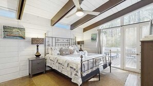 A bedroom with a bed, nightstands, a ceiling fan, and large windows. - Middlesex Beach house w/ outside shower, grill & community private beach (Bethany Beach)