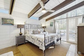 A bedroom with a bed, nightstands, a ceiling fan, and large windows. - Middlesex Beach house w/ outside shower, grill & community private beach (Bethany Beach)