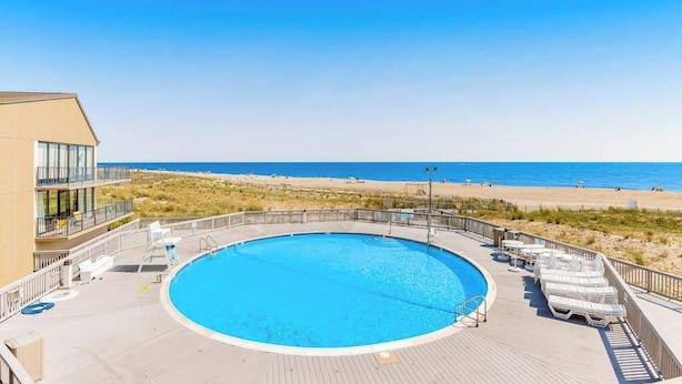 Ein kreisförmiger Pool mit Blick auf Strand und Meer.