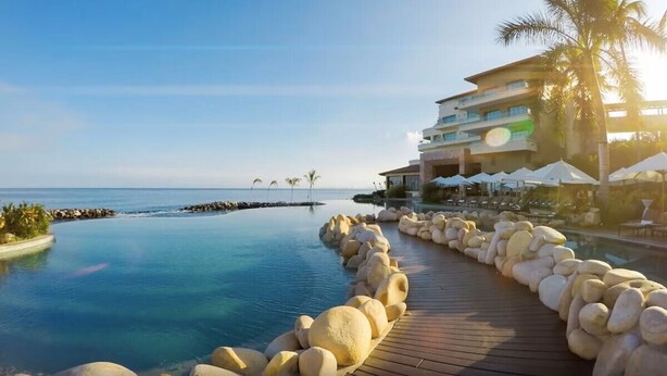 A resort with a pool, lounge chairs, and a view of the ocean. - Garza Blanca Preserve Resort & Spa (Puerto Vallarta)