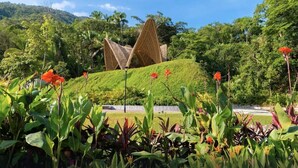 A garden with a unique architectural structure, lush greenery, and a clear sky. - Garza Blanca Preserve Resort & Spa (Puerto Vallarta)
