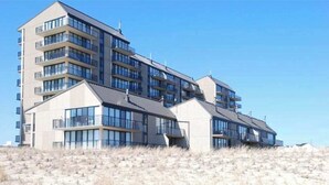 Un hotel de varios pisos con balcones, ventanas amplias y techo plano.