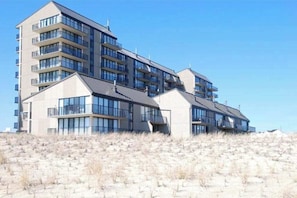A multi-story hotel with balconies, large windows, and a flat roof. - Sea Colony Condo in Oceanfront Complex w/Shared Pool, Private Washer/Dryer, WiFi (Bethany Beach)