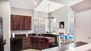 Una cocina moderna con armarios de madera oscura, lavavajillas y una isla grande.