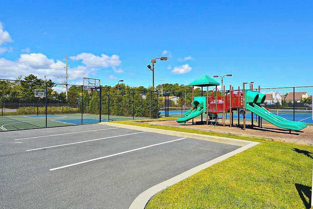 Un parque infantil con toboganes y una cancha de baloncesto.