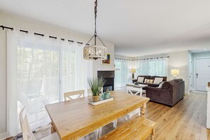 Ein geräumiger Wohnbereich mit Esstisch, Sofa und Kamin.