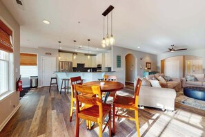 A modern interior with a dining area, kitchen, and living space. - Bayside Resort condo - fireplace, central AC & private W/D - pools, gym & golf (Selbyville)