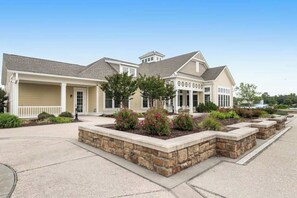 A two-story house with a garage, a covered porch, and a landscaped front yard with stone planters and shrubs. - Elegant home in Millville by the Sea with 2 pools, gym, dock & W/D (Millville)
