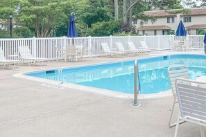 A rectangular pool with a white fence, lounge chairs, and umbrellas. - Bethany Pines townhome with pool, tennis, & private washer/dryer - near beach (Bethany Beach)