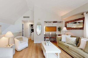 A modern living room with a sofa, armchairs, a coffee table, and a dining area with chairs and a table. - South Bethany cottage with private pool, firepit, & more - 5 minutes from beach (South Bethany)