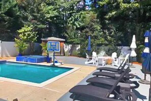A swimming pool with lounge chairs, a small gazebo, and a fenced area with trees. - South Bethany cottage with private pool, firepit, & more - 5 minutes from beach (South Bethany)