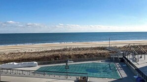 Área da piscina com vista para a praia e oceano.