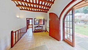 Un pasillo amplio con techo de madera, un ventanal arqueado grande y vistas al exterior.