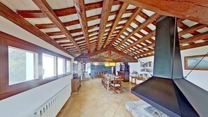 Una cocina amplia con una estufa grande, vigas de madera y piso de baldosas.