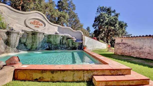 Una piscina con un muro de piedra y un letrero que dice 'Cano Golgocr'.