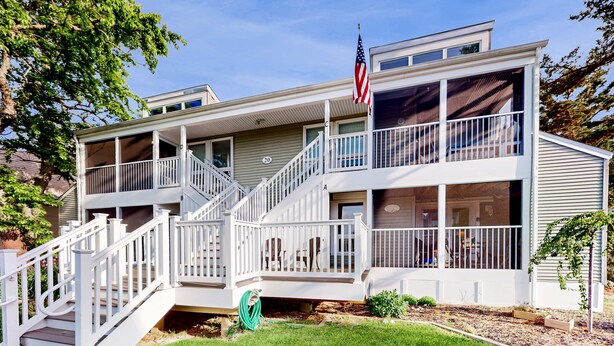 En toetagers bygning med balkon, trappe og et amerikansk flag.