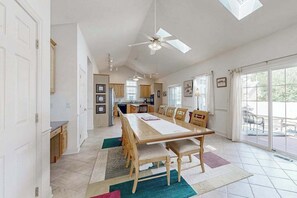 A spacious dining area with a long table, chairs, and a ceiling fan. - Mill Pond Acres home w/pool table, Xbox X, free WIFI (Lewes)