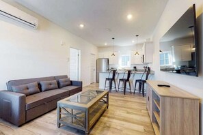 Eine moderne Wohnung mit Wohnzimmer, Küche und Essbereich.