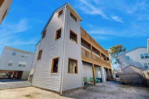 A two-story building with a garage, a balcony on the upper floor, and a small shed in the backyard. - Rainbow Cove condo w/WIFI, W/D, walk to restaurants & entertainment (Dewey Beach)