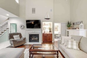 Ein Wohnzimmer mit Kamin, Fernseher und Treppe.