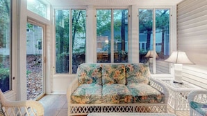 A room with a sofa, wicker chairs, and large windows. - Sea Colony Tennis townhouse w/ gym, tennis court, free WiFi, and balcony (Bethany Beach)