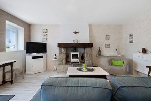 Ein Wohnzimmer mit Kamin, Fernseher und Essbereich.