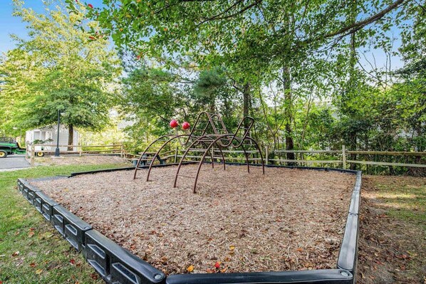 Un parque infantil con una estructura metálica para escalar y suelo de goma.