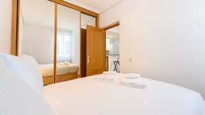 A hotel room with a bed, a wardrobe, and a kitchenette area. - (VAL203E) 1 bedroom apartment in the center of Madrid (Madrid)