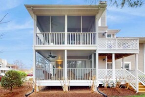 A two-story house with a balcony, a covered porch, and a visible chimney. - Sea Colony Condo Near Beach w/Shared Hot Tubs/Pools/Gym/Sauna/WiFi/AC/Deck + W/D (Bethany Beach)